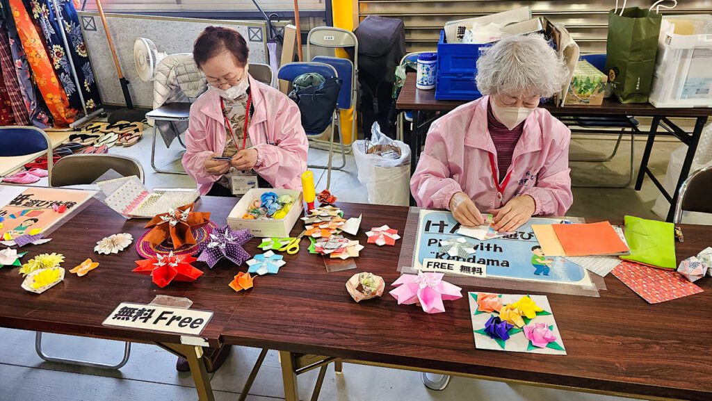Frauen die Origami im Hafengebäude falten